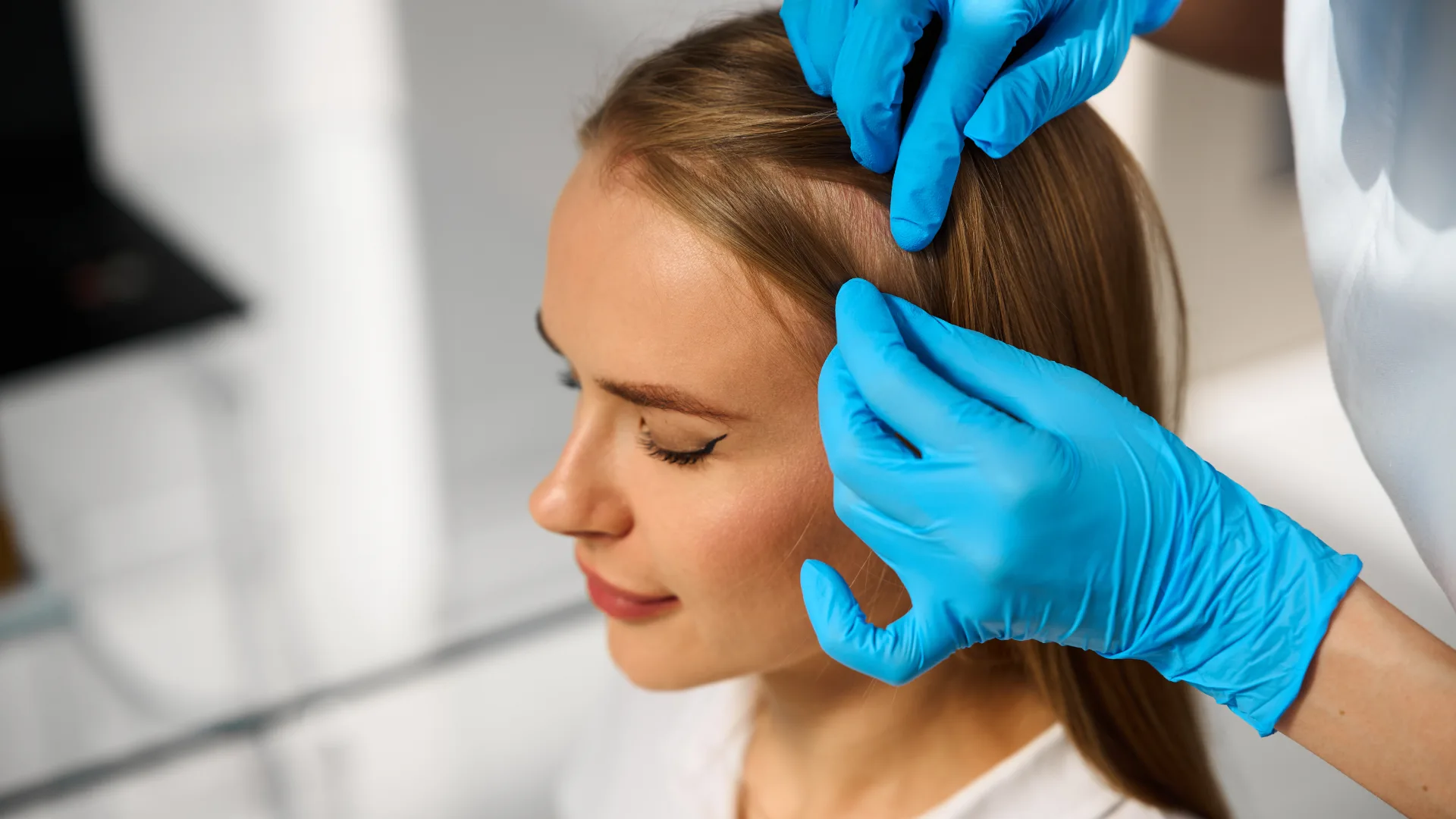 A clinician examining a client's scalp and hairline, treated at The Skin Firm Sheffield